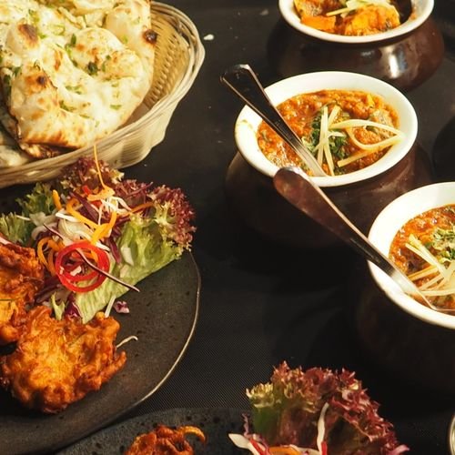 Spread of Indian curries, naan bread and pakoras